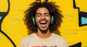 Young Man Smiling, Wearing Headphones Against Yellow Background