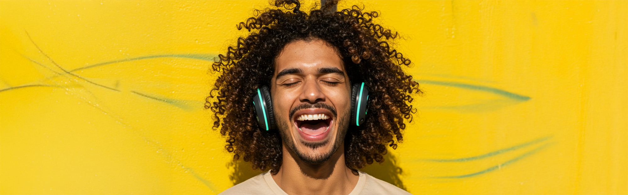 Young Man Wearing Headphones and Smiling Against Yellow Background