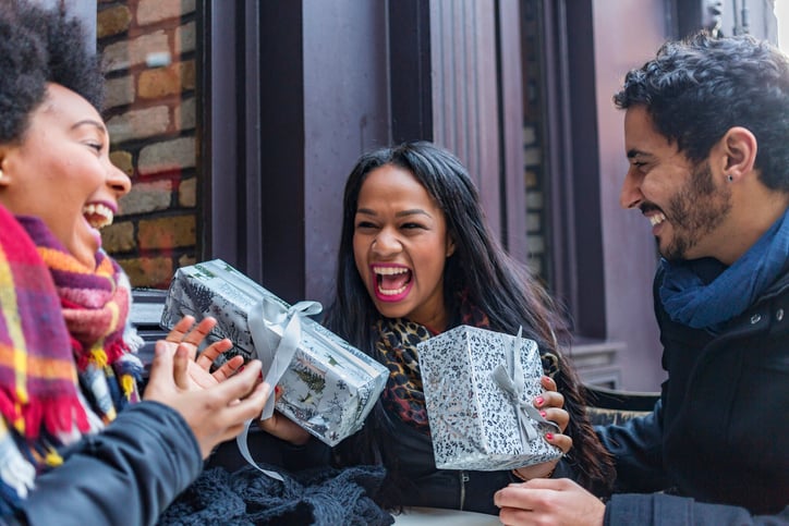 Friends Exchanging Winter Time Gifts and Smiling