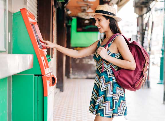Woman In Dress and Sunhat Using ATM Outside